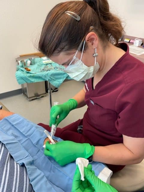 Second surgical provider treating a different skin condition in the dermatology surgery suite at Associated Dermatology in Helena, Montana.