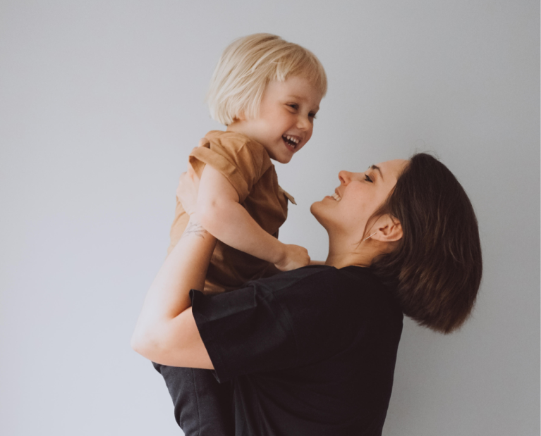 Mother holding toddler during pediatric dermatology visit